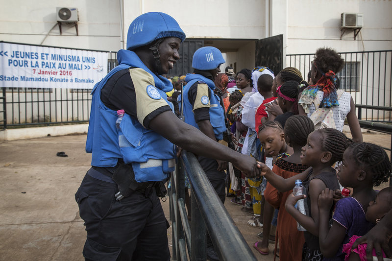 An Officer of the MINUSMA Formed Police Unit (FPU) speaks with Malians while patrolling outside Mamadou Konaté Stadium during a sport event. UN Photo: Marco Dormino